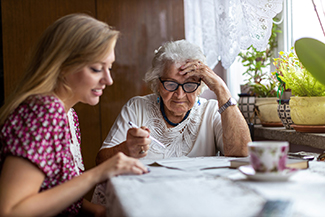 elder patient receiving help with paperwork